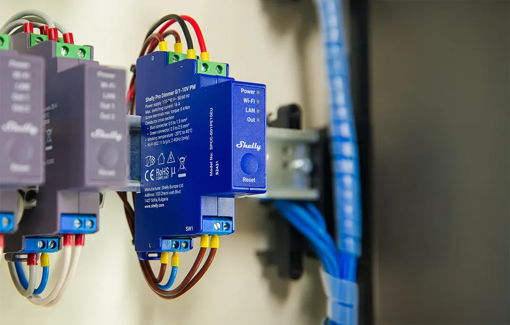 Nutikas valgusdimmer Shelly Pro Dimmer 0/1-10V PM sinise korpusega, paigaldatud DIN-liistule