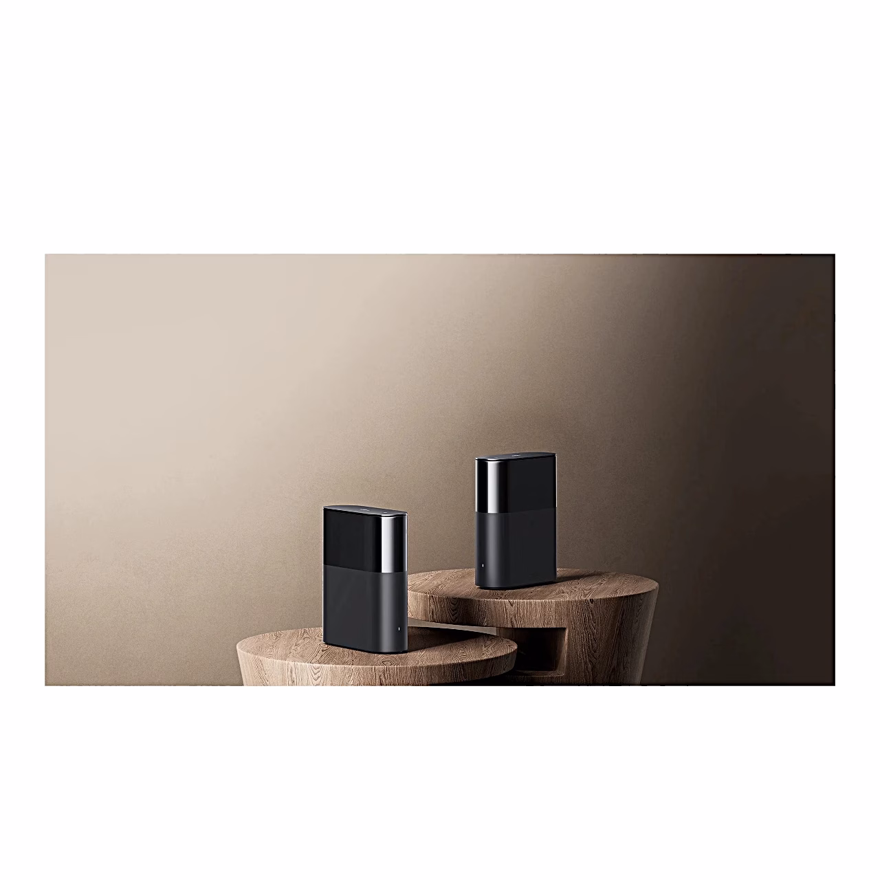 Kaks Xiaomi Mesh System BE3600 Pro ruuterit puidust alustel heledas toas