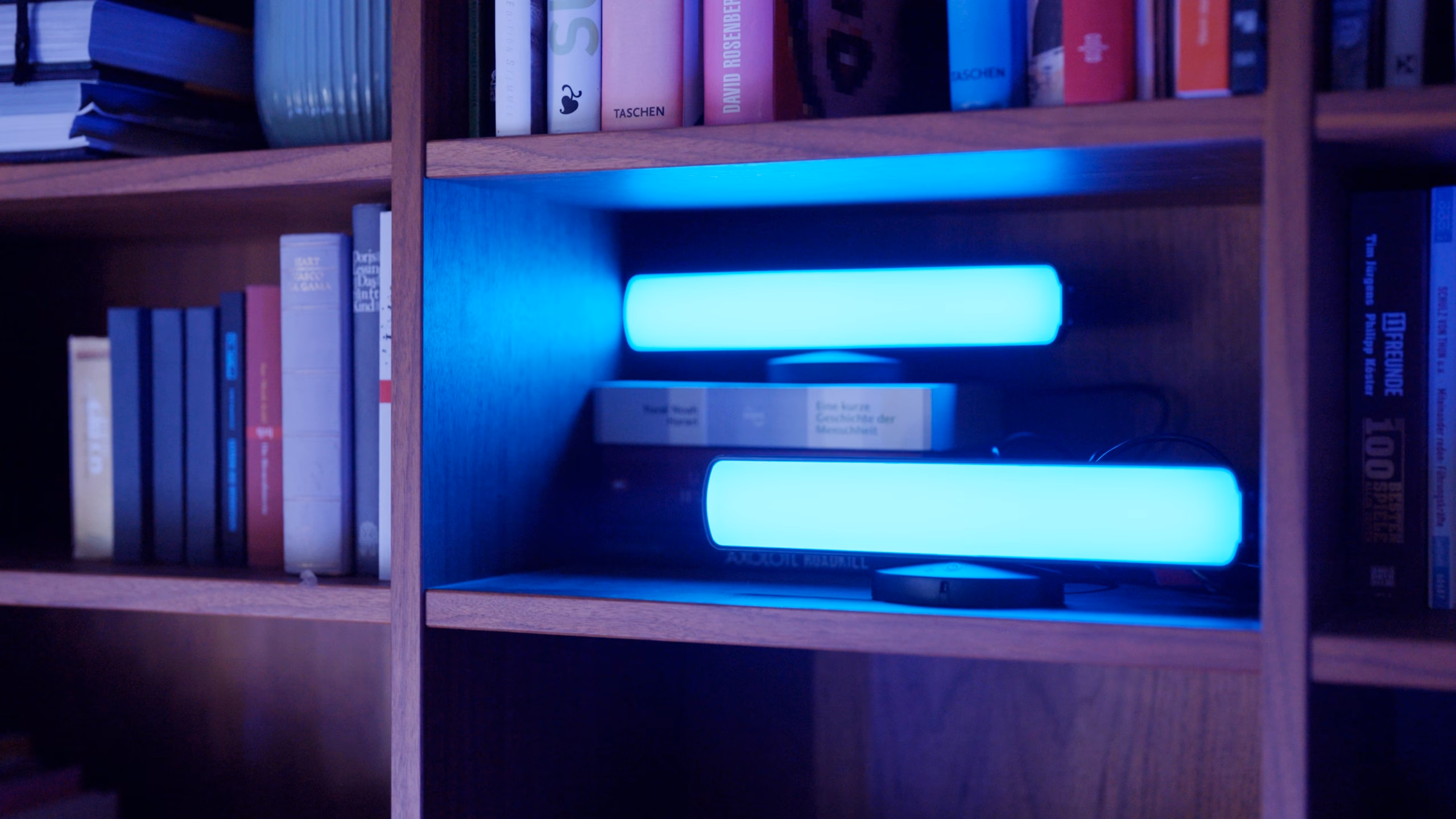 Riiulil kaks pikali Osram SMART+ Mood Light Bar riba helesinise valgusega