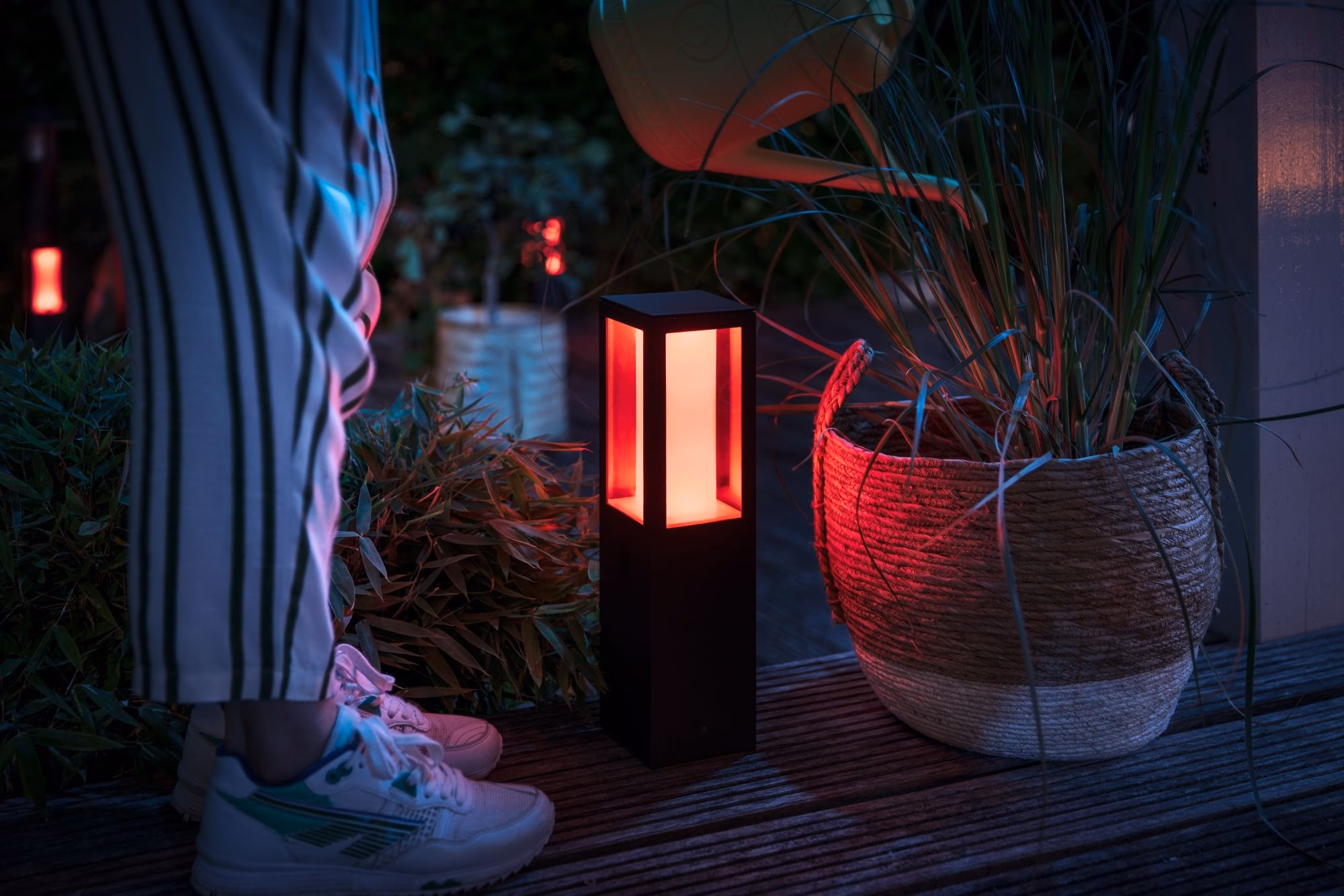 Philips Hue Impress Outdoor Pedestal punase valgusega terrassil möödujate kõrval